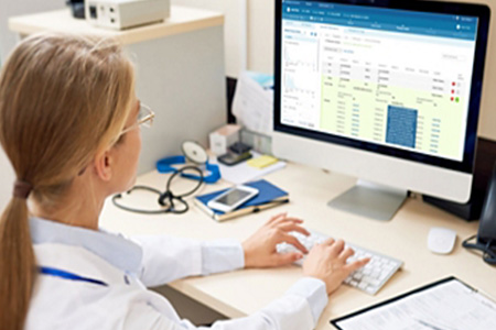 eine Frau im wei&szlig;en Kittel, die auf einer Tastatur tippt