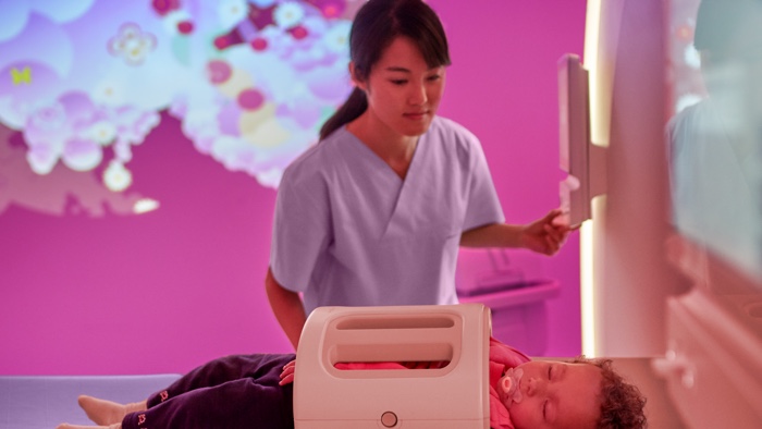 eine Frau in einem violetten Raum mit einem schlafenden Baby